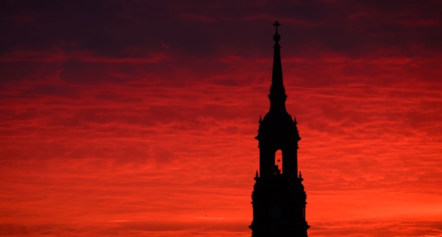 Roter Morgenhimmel hinter der Dreik&ouml;nigskirche in Dresden.  | Foto: Robert Michael/dpa