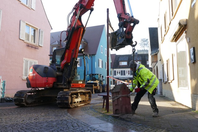 Die Mitarbeitenden der Firma Amann aus...en Poller aus Sandstein aus dem Boden.  | Foto: Sophia Ungerland