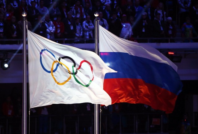 Die olympische Flagge und die russisch...ieder unter neutraler Flagge antreten.  | Foto: Hannibal Hanschke (dpa)