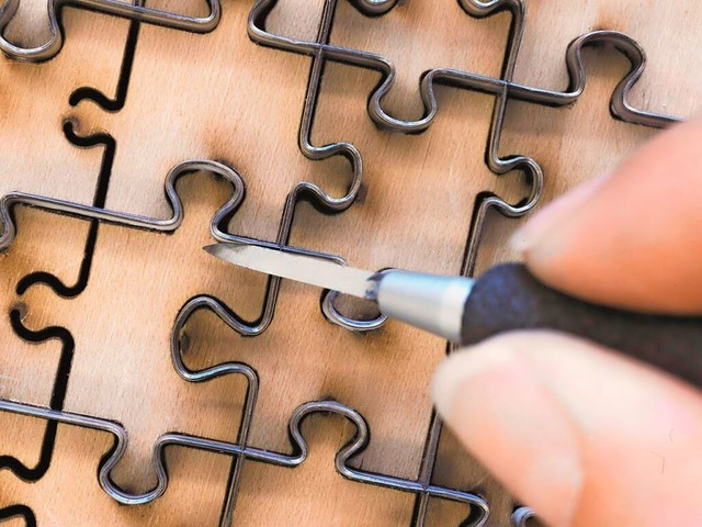 Stahlbnder werden in Form der Puzzleteile gebogen und auf einer Platte fixiert.  | Foto: Ravensburger Verlag GmbH