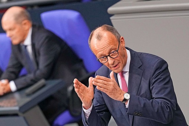 Oppositionsfhrer Merz bei der Debatte.... Im Hintergrund Bundeskanzler Scholz.  | Foto: Michael Kappeler (dpa)