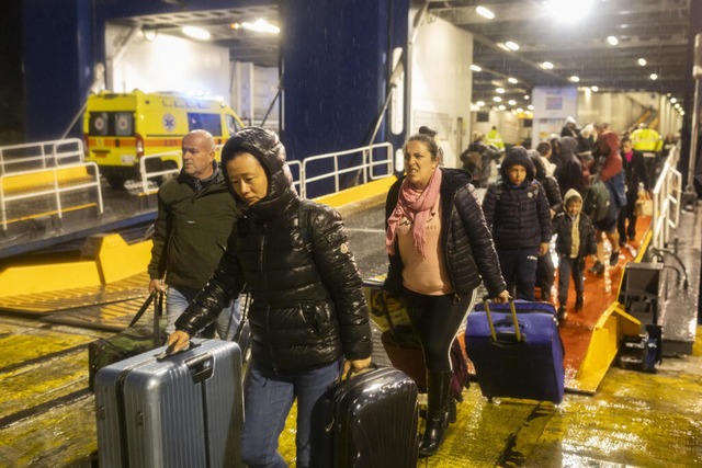 Menschen steigen im Hafen von Pirus i...ische Insel Santorini verlassen haben.  | Foto: Socrates Baltagiannis (dpa)