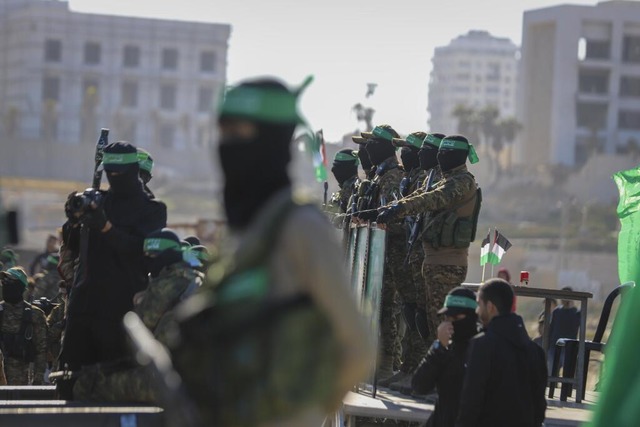 Hamas-Kmpfer stehen am Ort der berga...iegel an das Rote Kreuz in Gaza-Stadt.  | Foto: Mohammed Hajjar (dpa)