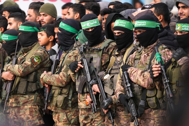 Die &Uuml;bergabe der Geiseln an das R...hlreiche vermummte Hamas-K&auml;mpfer.  | Foto: Abdel Kareem Hana/AP/dpa