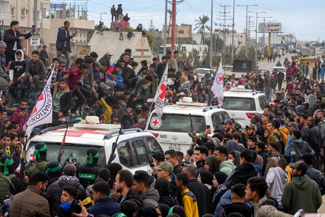 Hunderte Schaulustige verfolgten die G...n Vertreter des Roten Kreuzes vor Ort.  | Foto: Abdel Kareem Hana/AP/dpa