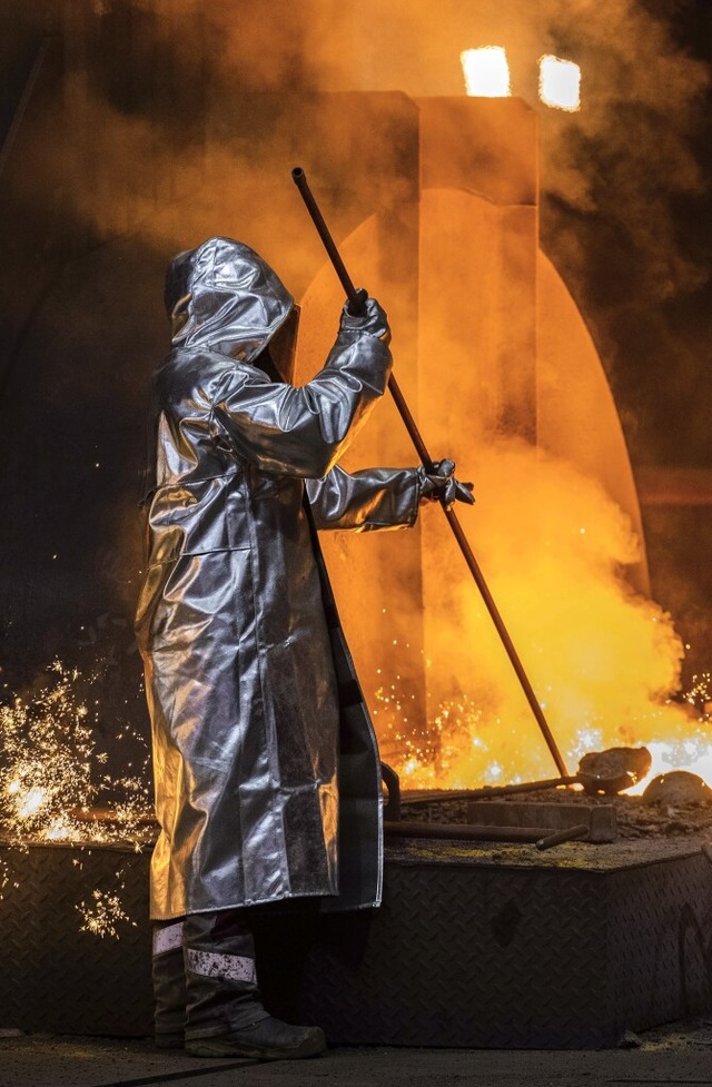 Ein Stahlarbeiter von Thyssenkrupp prft den Roheisen an einem  Hochofen.  | Foto: Rolf Vennenbernd (dpa)