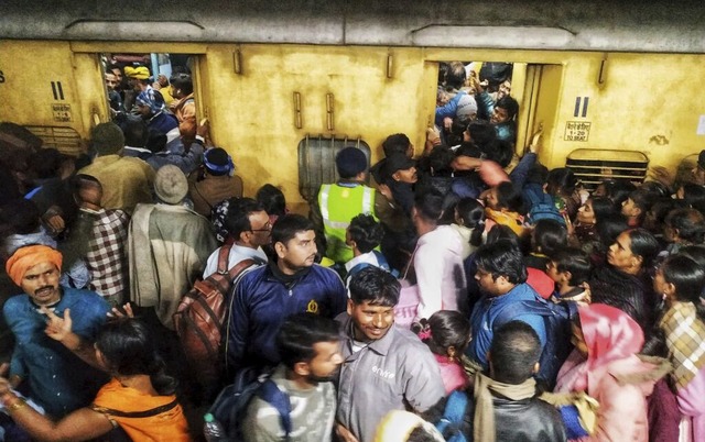 Fahrgste drngeln sich beim Einsteigen in einen Zug am Bahnhof von Neu-Delhi.  | Foto: Uncredited/AP/dpa