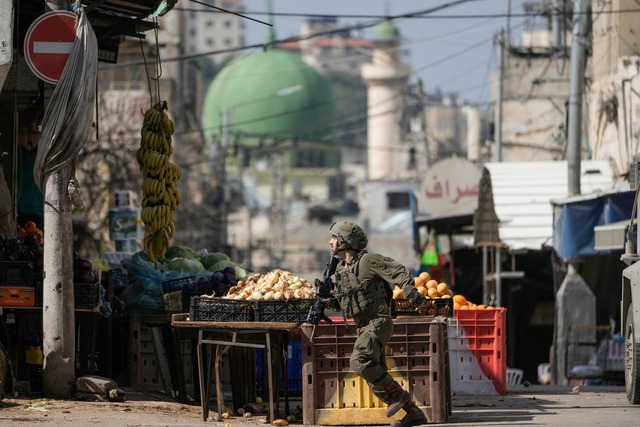 Ein israelischer Soldat l&auml;uft w&a...rend einer Armeeoperation in Stellung.  | Foto: Majdi Mohammed/AP/dpa