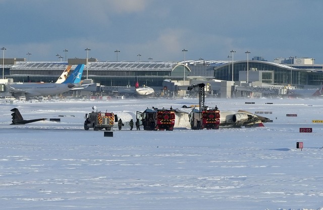 Feuerwehrleute des Toronto Pearson Int...iegenden Flugzeug der Delta Air Lines.  | Foto: Teresa Barbieri/The Canadian Press/AP/dpa