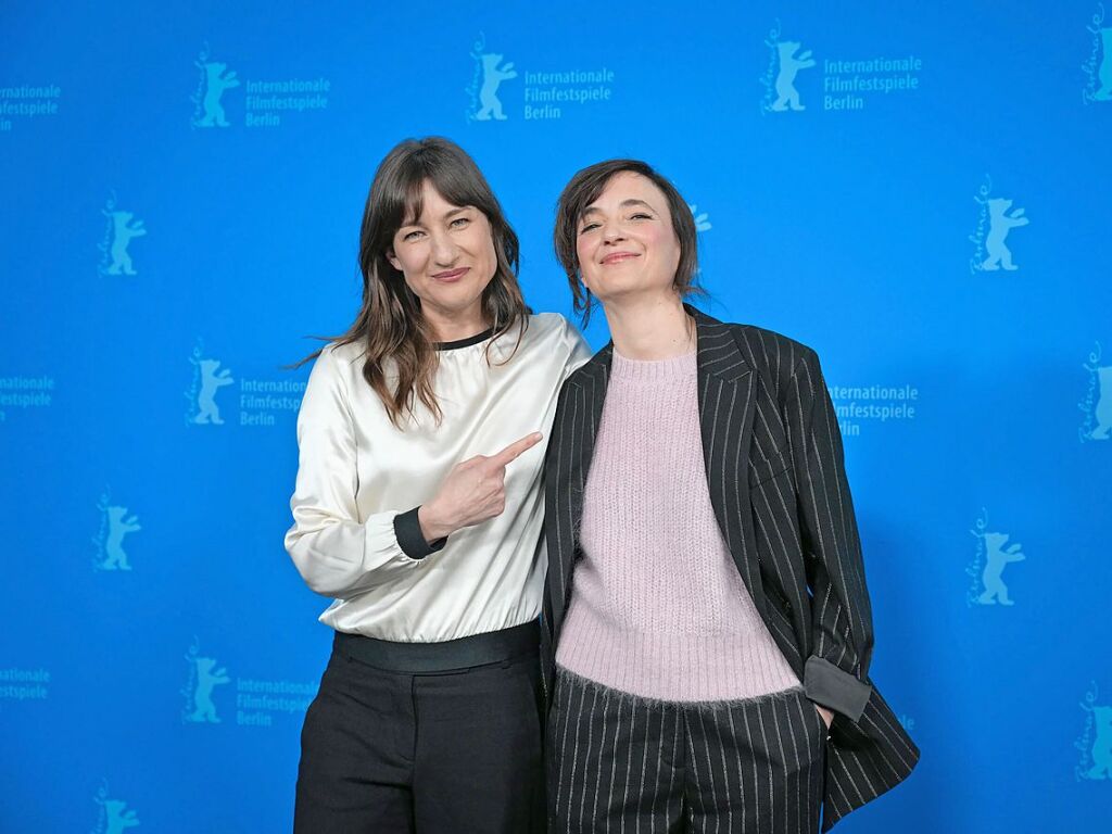 Schauspielerin Marie Leuenberger (l) und Regisseurin Johanna Moder (r) stehen beim Photocall des Films "Mother's Baby" (Wettbewerb) nebeneinander vor der blauen Wand.