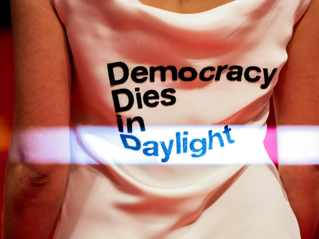 Democracy, dies in daylight steht am Erffnungsabend der Berlinale auf dem Roten Teppich auf dem Kleid von Aktivistin Luisa Neubauer.