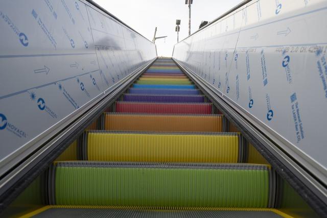 Die neue Rolltreppe am Freiburger Hauptbahnhof hat bunte Stufen wie ein Regenbogen