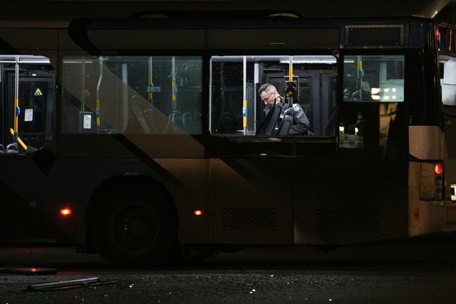 Ein Polizeibeamter inspiziert einen Bus.  | Foto: Ohad Zwigenberg/AP/dpa