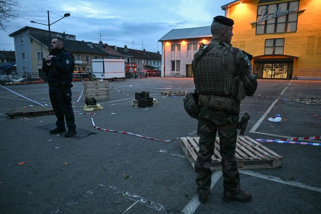 Ein Polizist und ein Soldat stehen am Ort des Messerangriffs in Mulhouse.  | Foto: Sebastien Bozon (dpa)