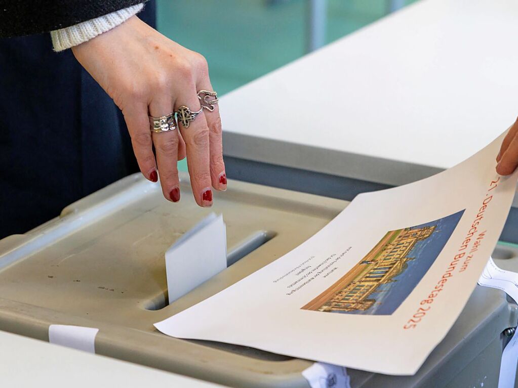 Erfurt: Eine Frau wirft ihren Wahlzettel zur Bundestagswahl in einem Wahllokal in der Moritzschule in die Wahlurne.