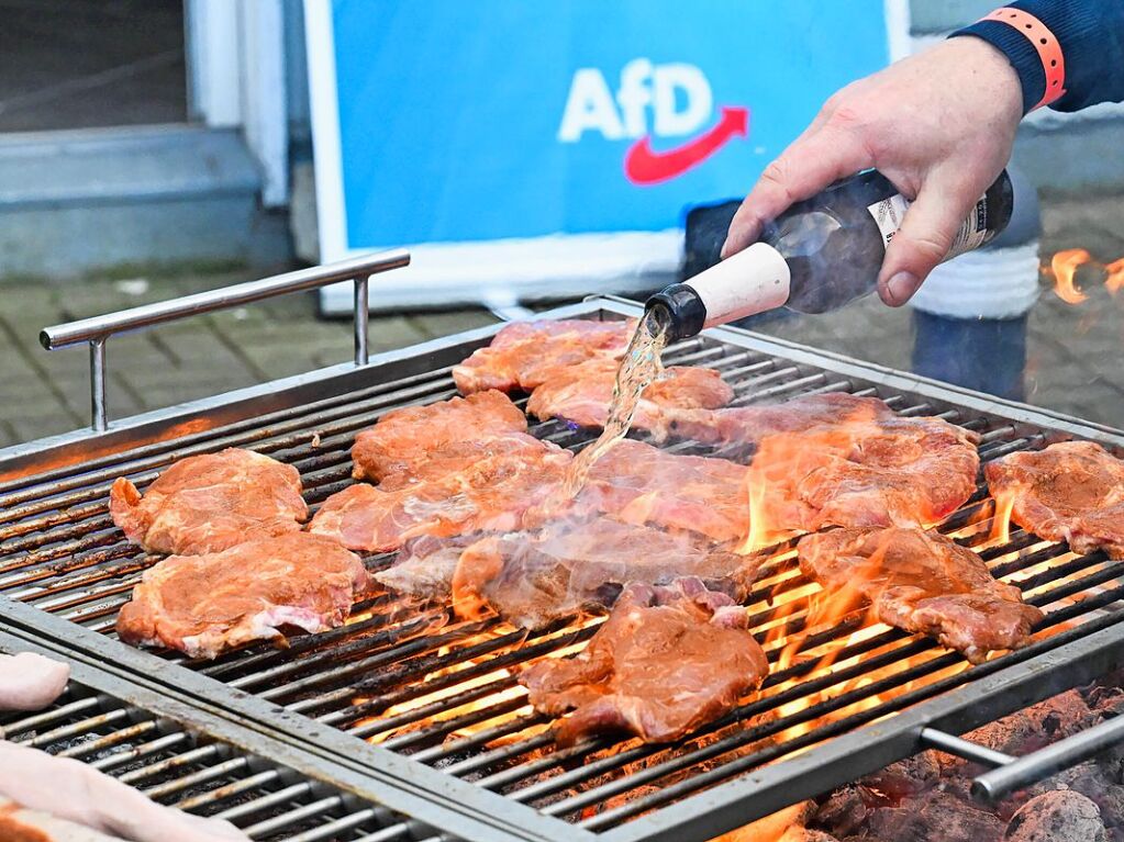 Ein Mann lscht Steaks mit Bier beim Grillen bei der Wahlparty der Alternative fr Deutschland in der Bundesgeschftsstelle der AfD in Berlin.