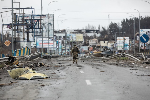 Butscha im April 2022: Ein Soldat geht...er Strae in der Pendlerstadt gettet.  | Foto: Mykhaylo Palinchak (dpa)