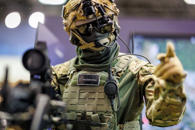 Eine Puppe mit einem Gewehr und der Ka...uuml;rnberger Waffenmesse Enforce-Tac.  | Foto: Daniel Karmann/dpa