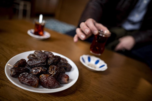 Eine Person sitzt bei Datteln und Tee ...r Sehitlik-Moschee in Berlin-Neuklln.  | Foto: Fabian Sommer (dpa)