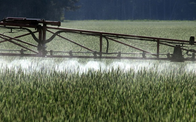 Ein Landwirt verspr&uuml;ht mit einem ...er Vergangenheit zu viel Geld bezahlt.  | Foto: Peter F&ouml;rster/dpa