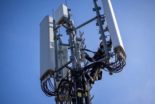 Einer von Zehntausenden Mobilfunk-Mast... an dem gerade ein Techniker arbeitet.  | Foto: Daniel Karmann/dpa