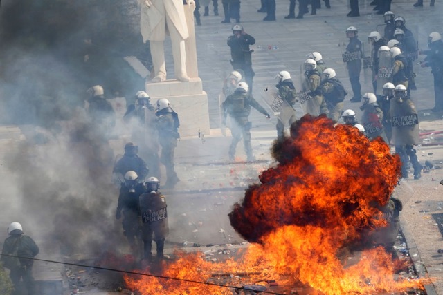 Vermummte schleuderten nach der Demo in Athen Brands&auml;tze.  | Foto: Thanassis Stavrakis/AP/dpa