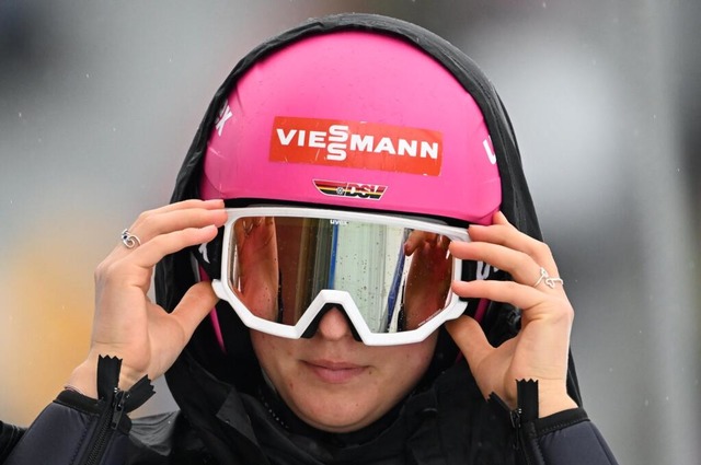 Nathalie Armbruster schtzt sich vor dem Regen in Trondheim.  | Foto: Hendrik Schmidt (dpa) 