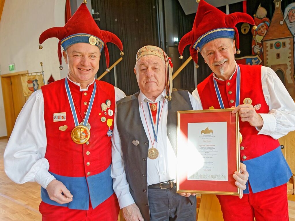 Oberzunftmeister Ralph Baumann (l.) und Zeremonienmeister Clemens Sexauer (r.) ehren Hans Forster fr 65 Jahre Mitgliedschaft in der Narrenzunft.