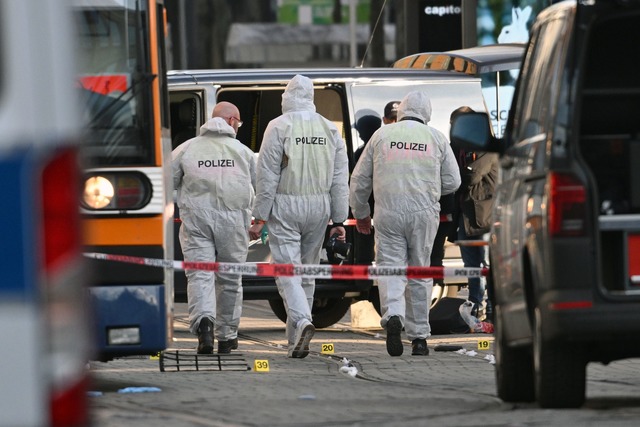 Beamte der Spurensicherung untersuchen den Tatort.  | Foto: Boris Roessler/dpa