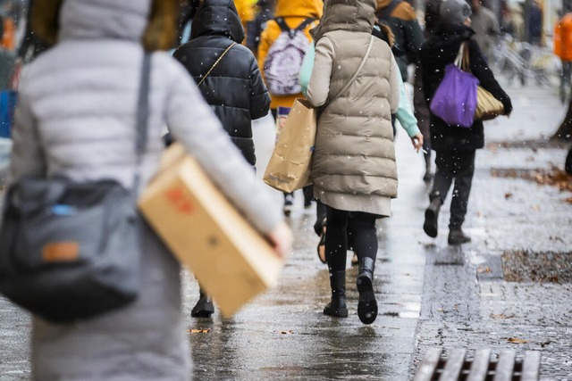 Passanten gehen mit Einkaufstaschen au... spazieren - natrlich in Pufferjacke.  | Foto: Christoph Soeder (dpa)