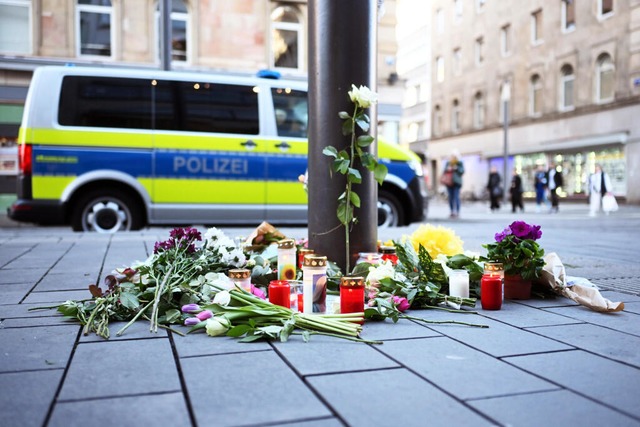 Kerzen und Blumen liegen in der Nhe d...tzes an einer Straenbahn-Haltestelle.  | Foto: Uli Deck (dpa)