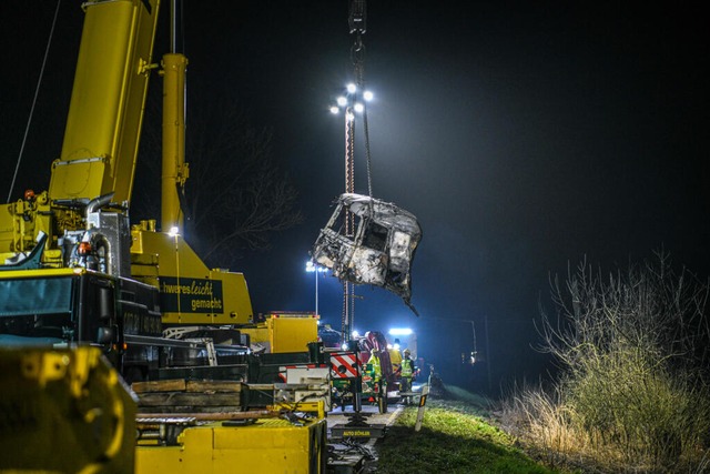 Ein Kran hebt ein total verkohltes Teil in die Luft.  | Foto: Jason Tschepljakow (dpa)