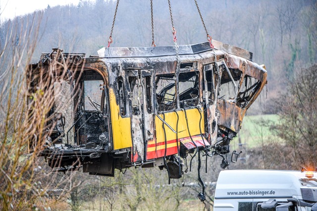 Der erste Teil des ausgebrannten Waggons wird geborgen.  | Foto: Jason Tschepljakow/dpa