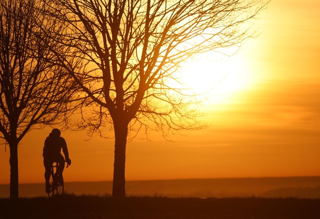 Ein Radfahrer ist am Morgen kurz nach ...in Oranget&ouml;nen verf&auml;rbt hat.  | Foto: Thomas Warnack/dpa