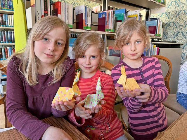 Nele, Lara und Nora zeigen stolz ihre Origami-Ergebnisse.  | Foto: Lina Boegel