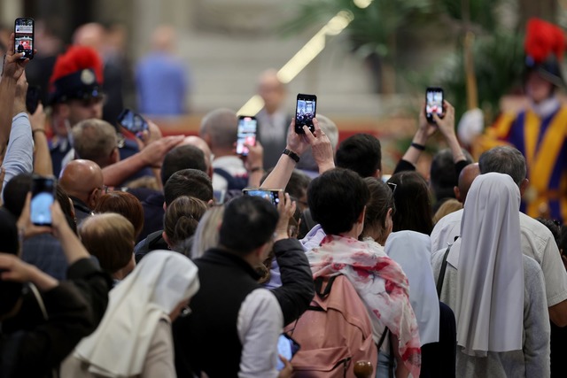Mit den Smartphones machen Gl&auml;ubige ein Foto vom toten Papst.  | Foto: Christoph Reichwein/dpa