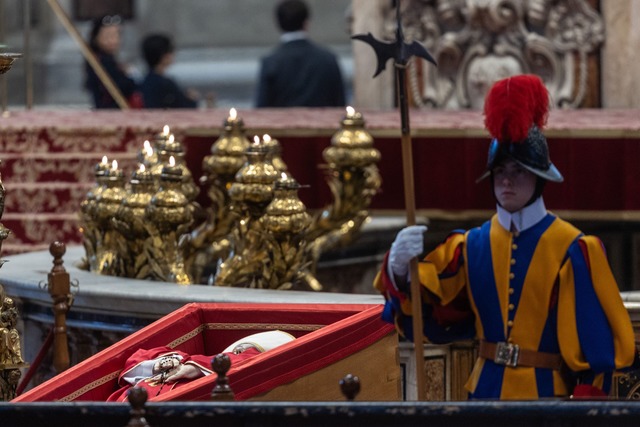 Ein Wachmann der Schweizergarde neben dem toten Papst.  | Foto: Oliver Weiken/dpa