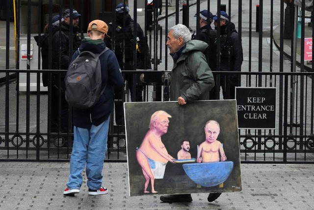 Ein K&uuml;nstler geht in London mit e...n Toren der Downing Street 10 entlang.  | Foto: Frank Augstein/AP/dpa