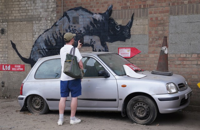 Ein Kunstwerk von Banksy in der Westmo... das auf ein Auto zu klettern scheint. | Foto: Lucy North (dpa) Ein Kunstwerk von Banksy in der Westmo... das auf ein Auto zu klettern scheint. | Foto: Lucy North (dpa)