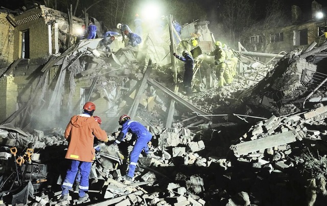 Rettungskräfte stehen in Trümmern nach...f auf die ukrainische Hauptstadt Kiew. | Foto: Efrem Lukatsky (dpa) Rettungskräfte stehen in Trümmern nach...f auf die ukrainische Hauptstadt Kiew. | Foto: Efrem Lukatsky (dpa)