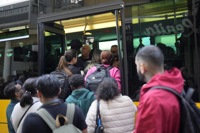Menschen steigen in einen Bus, nachdem die U-Bahn in Lissabon nicht mehr fhrt.  | Foto: Armando Franca (dpa)