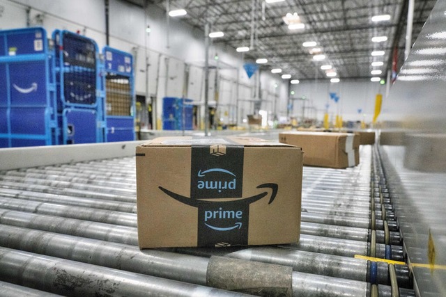 Ein Amazon-Paket bewegt sich auf einem Förderband. | Foto: Richard Vogel (dpa) Ein Amazon-Paket bewegt sich auf einem Förderband. | Foto: Richard Vogel (dpa)