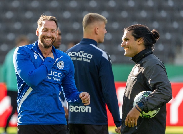 Arminia-Coach Mitch Kniat (l) geht mit bester Laune ins Pokalfinale.  | Foto: Soeren Stache/dpa