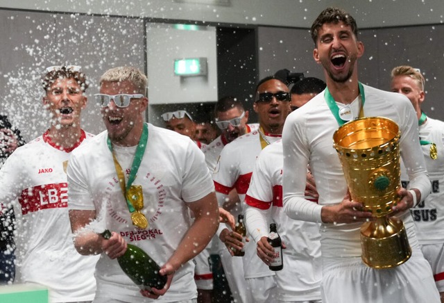 Mit einer Sektdusche und dem Pokal bet... des VfB den Raum der Pressekonferenz. | Foto: Soeren Stache (dpa) Mit einer Sektdusche und dem Pokal bet... des VfB den Raum der Pressekonferenz. | Foto: Soeren Stache (dpa)