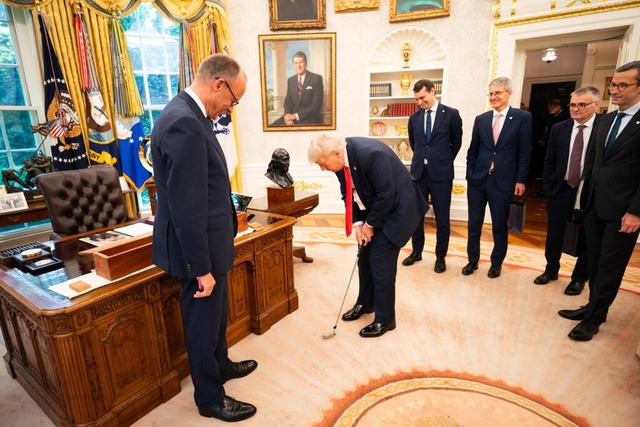 Merz schenkt Donald Trump einen Golfschlger.  | Foto: Steffen Kugler (dpa)