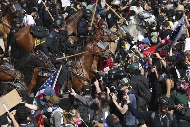 Demonstranten stoen in Los Angeles mit berittenen Polizisten zusammen.  | Foto: Ethan Swope (dpa)