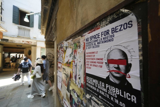 Ein Protestplakat mit der Aufschrift &...os" ist an einer Wand angebracht. | Foto: Luca Bruno (dpa) Ein Protestplakat mit der Aufschrift &...os" ist an einer Wand angebracht. | Foto: Luca Bruno (dpa)