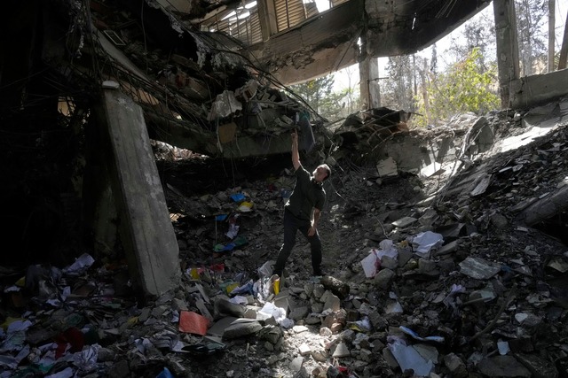 Ein Mann zeigt auf Sch&auml;den im B&u...ngnisses in der iranischen Hauptstadt.  | Foto: Vahid Salemi/AP/dpa