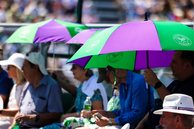 Unter der stechenden Sonne suchen die Zuschauer Schutz.  | Foto: Frank Molter/dpa