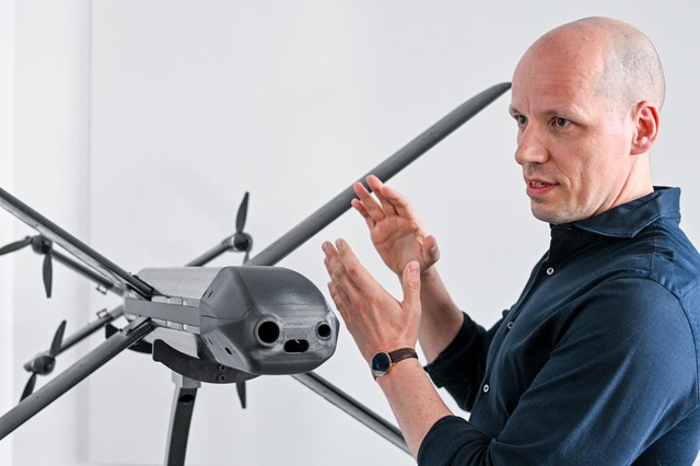 Ein Modell der HX-2-Drohne von Helsing...der und Co-Firmenchef Gundbert Scherf.  | Foto: Jens Kalaene/dpa